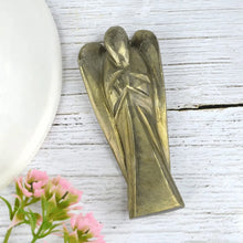 Load image into Gallery viewer, Pyrite angel figurine on a white wooden surface with pink flowers
