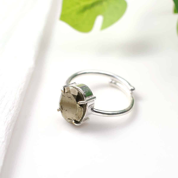 Pyrite diamond cut adjustable ring placed on a white desk, symbolizing willpower, confidence and good fortune.