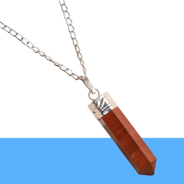 A silver chain necklace with a polished red crystal point pendant featuring a metallic cap.