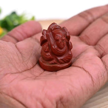 Load image into Gallery viewer, Red Jasper Ganesh crystal figurine held in hand, symbolizing protection, strength and success with natural healing energy.
