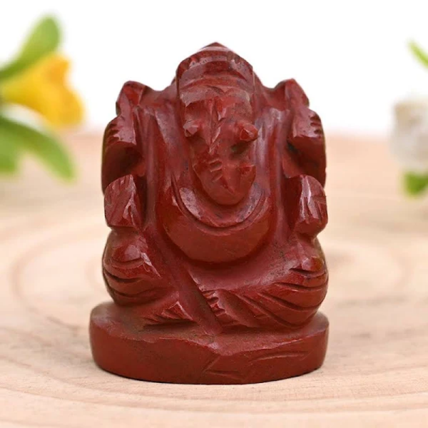 Red Jasper Ganesh crystal figurine photographed in natural light, symbolizing protection, strength and success.