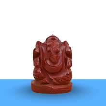 Load image into Gallery viewer, Red Jasper Ganesh figurine on a clean white and blue minimalist background, symbolizing protection, strength and success.

