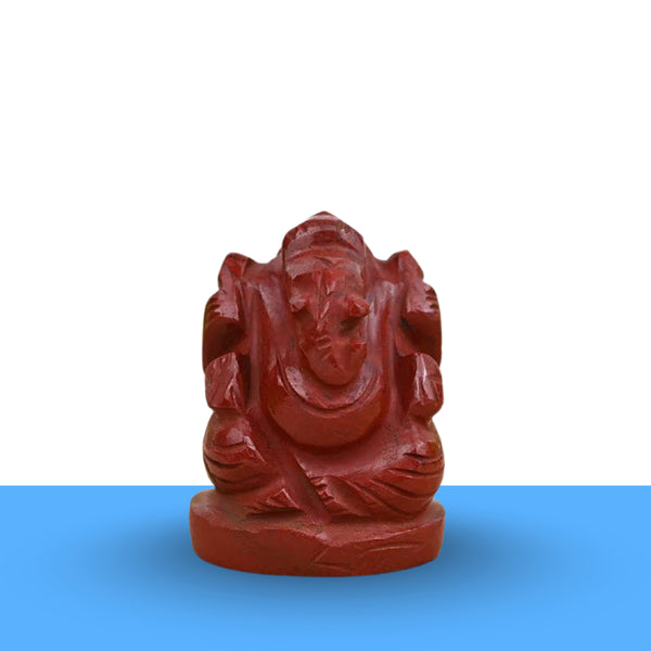 Red Jasper Ganesh figurine on a clean white and blue minimalist background, symbolizing protection, strength and success.