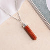 Red Jasper pencil pendant with a silver chain placed on a soft beige and white background