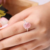 Rose Quartz oval diamond cut ring on a clean white background with blue accents, enhancing love, harmony and self-love.