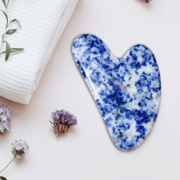 Sodalite face Gua Sha beauty tool featured for calming relaxation, improved focus and expressive skin benefits.