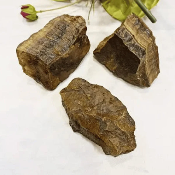 Tiger Eye raw stone placed on a white table, symbolizing focus, courage, and clarity.