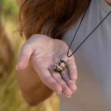 Load image into Gallery viewer, Tiger Eye crystal pendant on black marble surface with luxurious golden reflections
