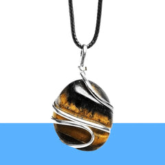 Tiger Eye gemstone pendant displayed on a glossy reflective surface highlighting gold streaks and polish