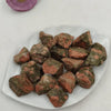 Unakite raw stones displayed on a white plate, symbolizing balance, healing, and growth.