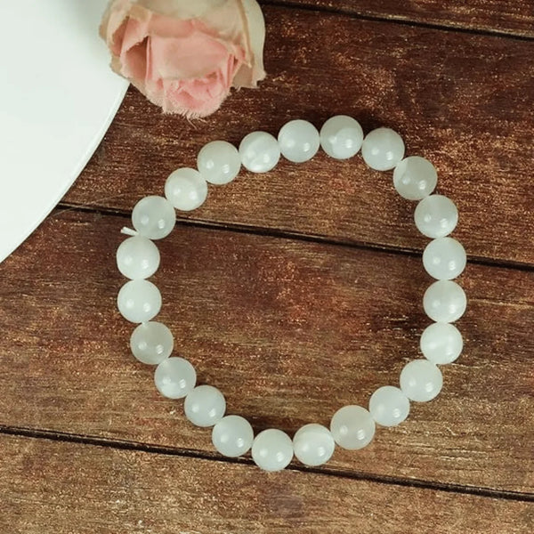 White bead bracelet placed on a wooden table